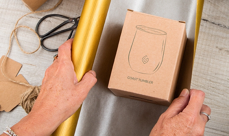 Hands wrapping a product with a gold wrapping paper 2 |
