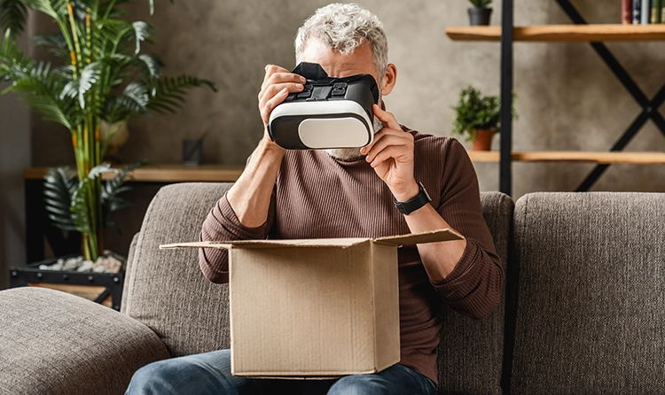 Middle aged man sitting ona sofa and looking through a VR set 1 |